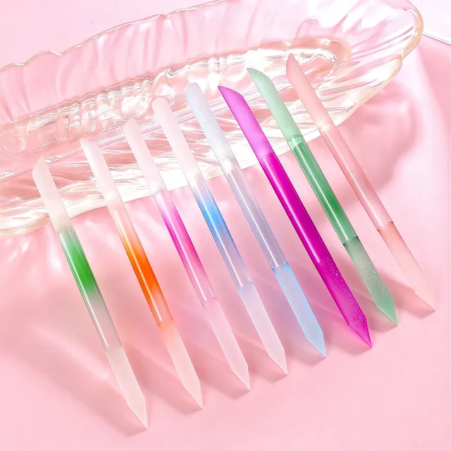 Ten translucent crystal-glass nail sticks in assorted colours fanned across a glass dish