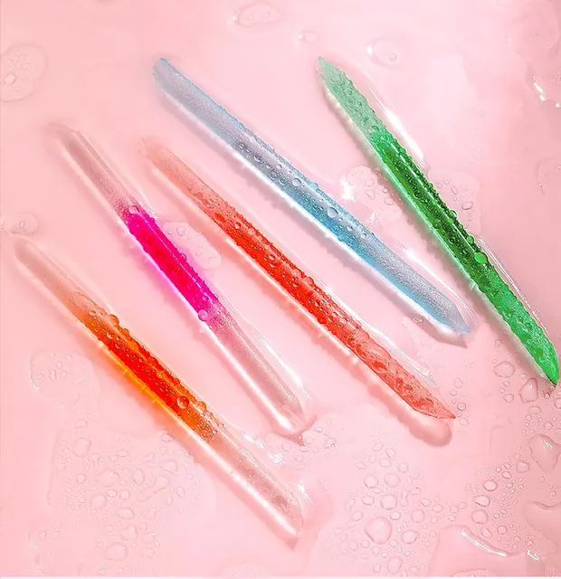 Crystal-glass nail sticks in blue, magenta, pink and green with their tips toward the camera