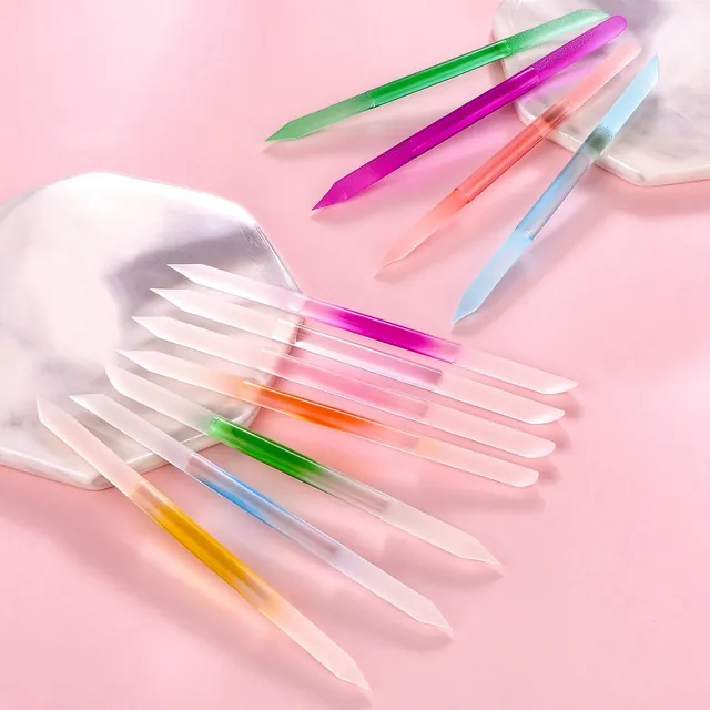 Glossy coloured crystal nail sticks with water droplets on the surface