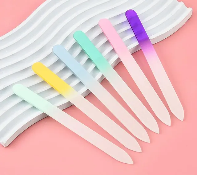 Seven gradient glass nail files fanned across a wave-pattern plinth