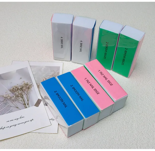Three polishing blocks beside two nail files on a desk, printed File Nail Edge and Buff Smooth Nail