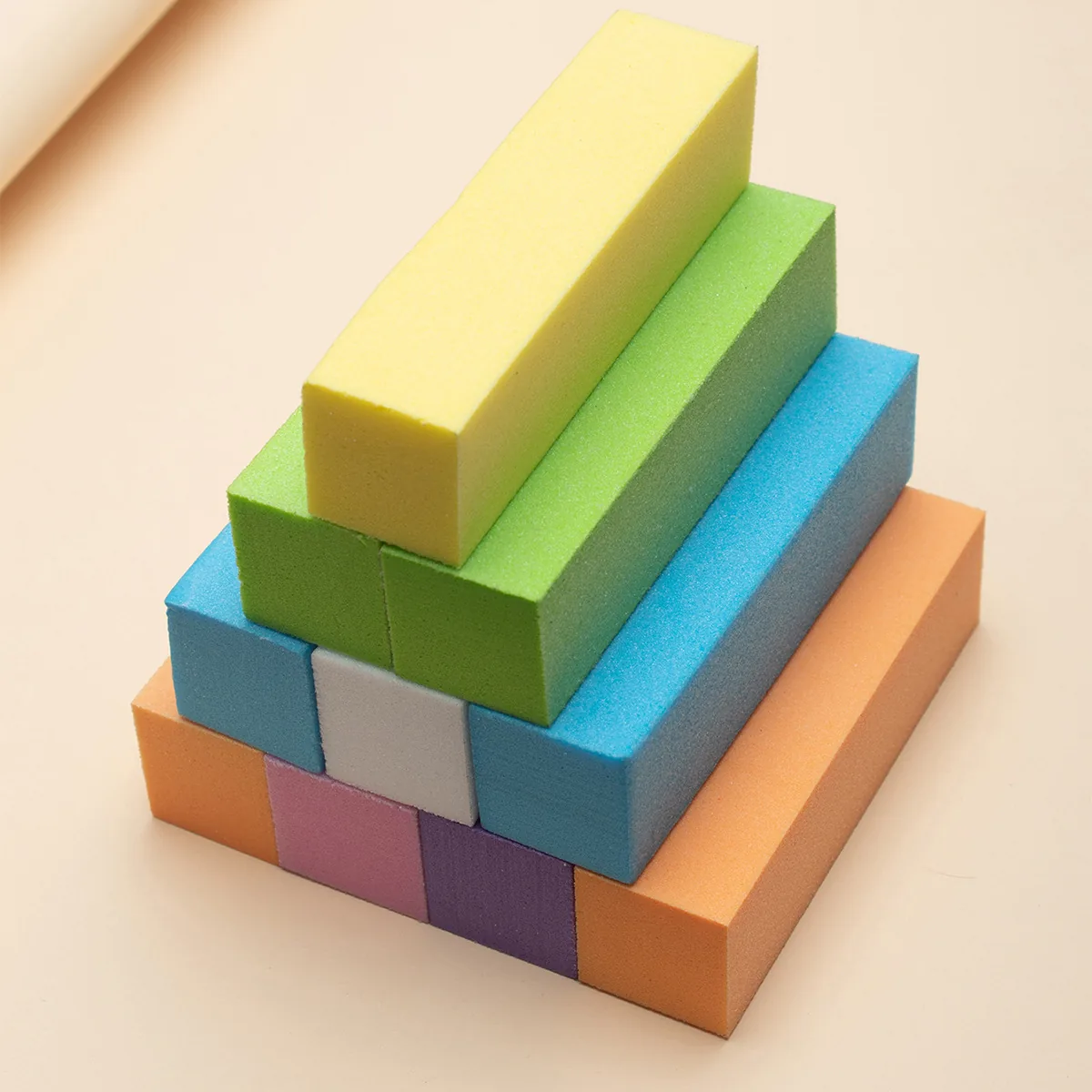 Pyramids of coloured four-sided sanding blocks in yellow, orange, blue, green and pink
