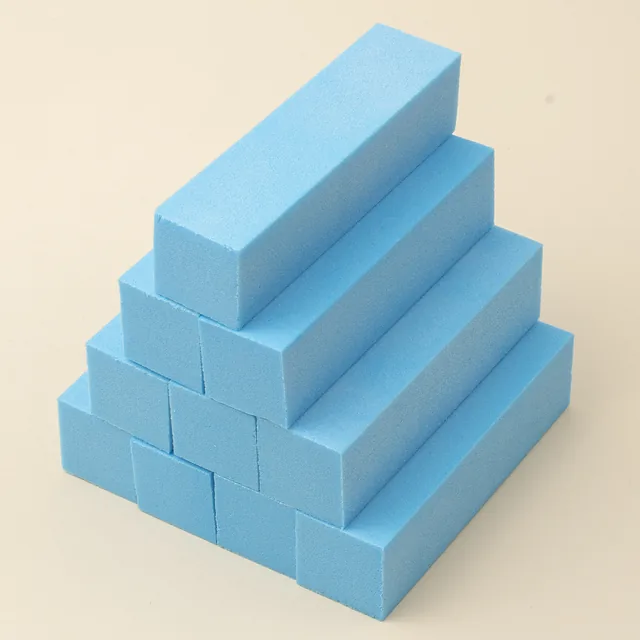 Hand squeezing a green sanding block to show it returns to shape
