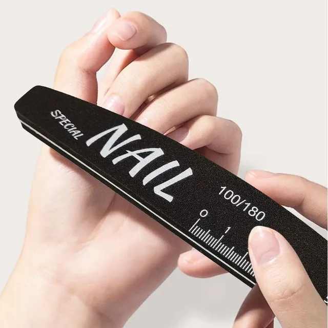 Hand holding one black polishing nail file showing its printed scale ruler