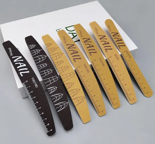 Seven polishing nail files in black and dark yellow arranged on a grey surface