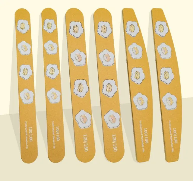 Six yellow egg-flower print wooden nail files flat-laid on a cream background