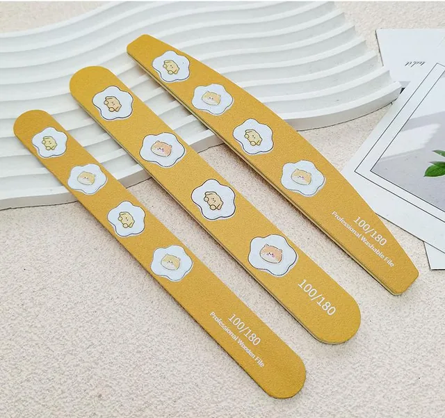 Three yellow egg-flower nail files resting on a white ripple tray beside a magazine